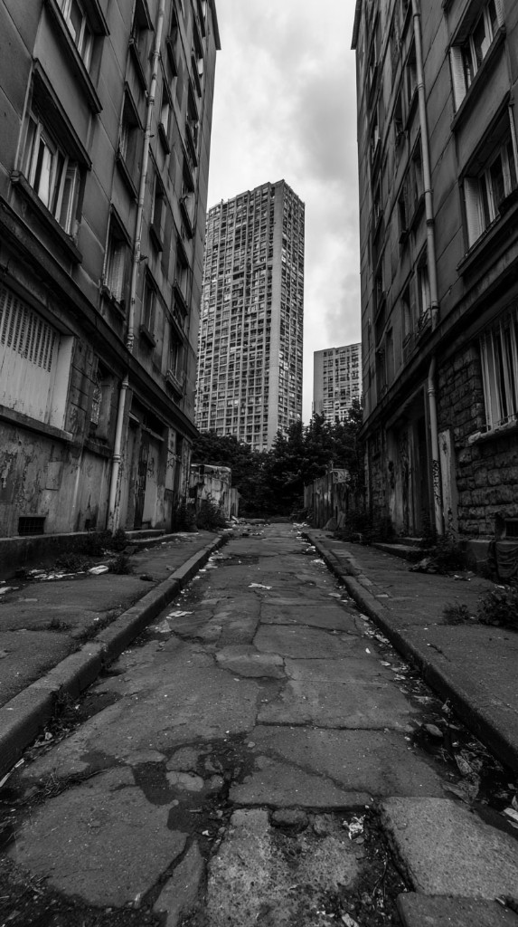 No Zone — cracked alley between buildings toward the towers