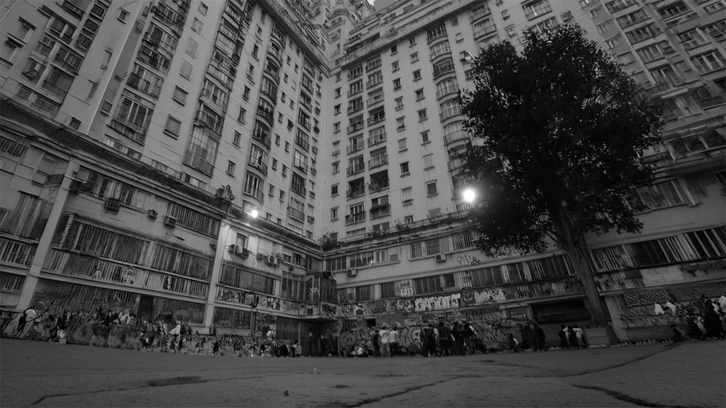 No Zone — courtyard of high-rises with a tree and graffiti