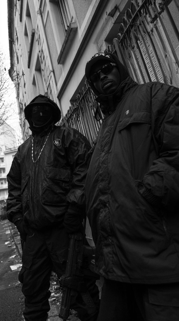 No Zone — two figures in black standing by an iron fence